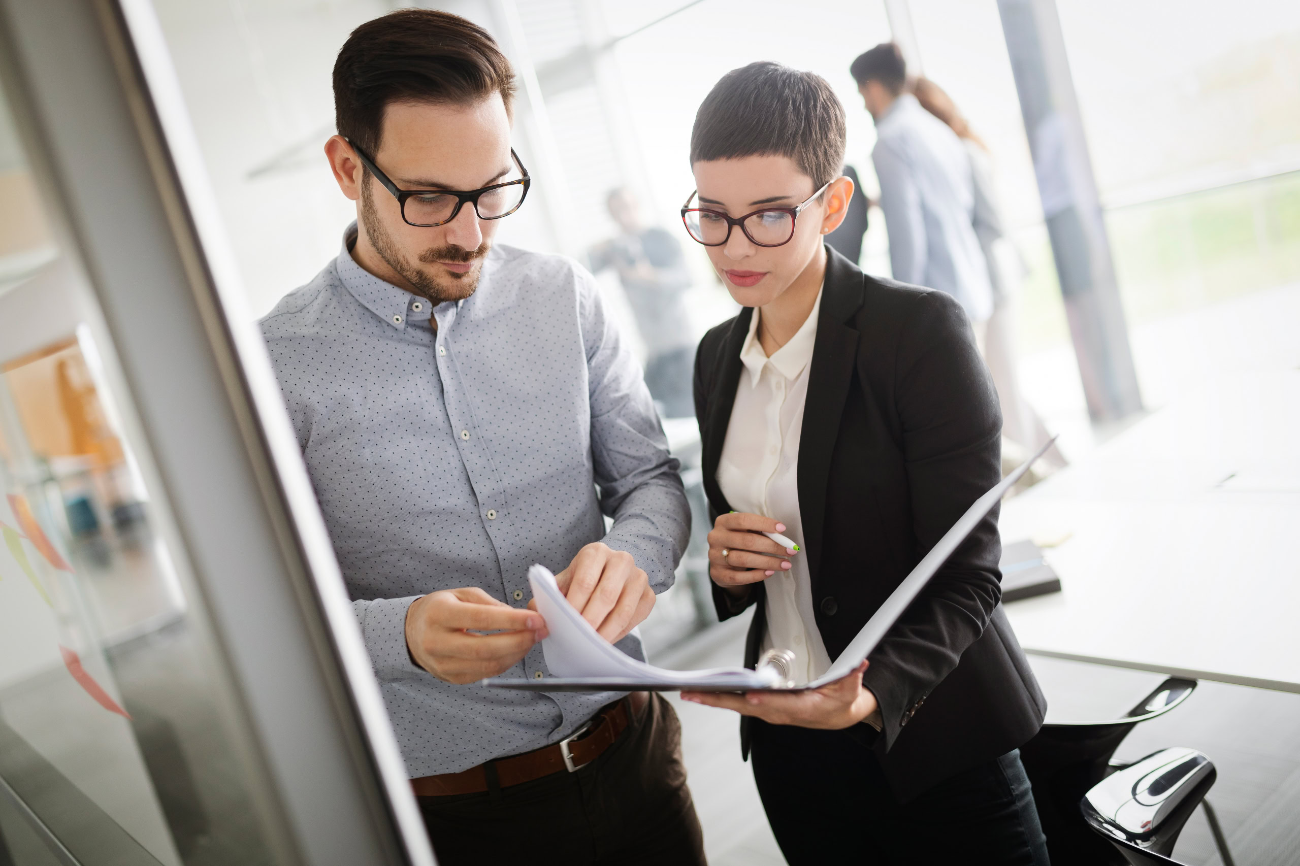 Frau und Mann schauen gemeinsam durch Dokumente